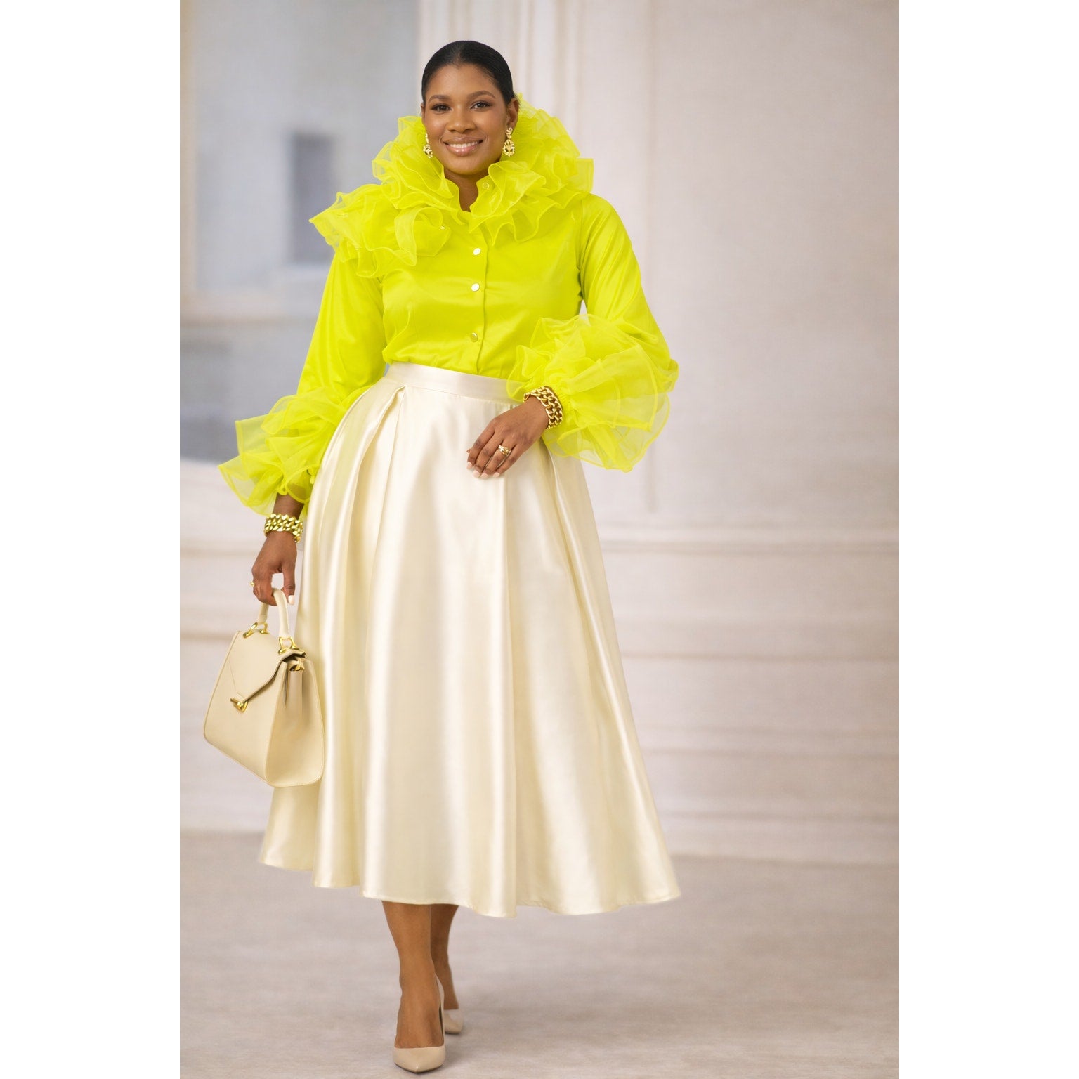 Woman wearing a bright yellow ruffled blouse with a cream skirt indoors.