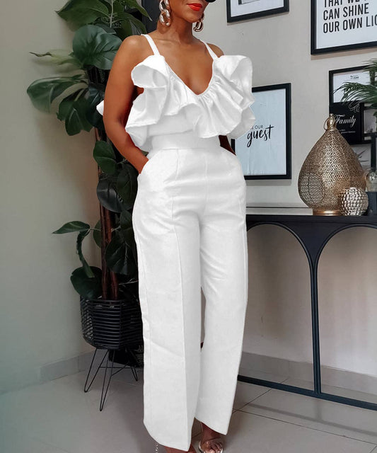 Woman in a white outfit standing in a room with decor elements.