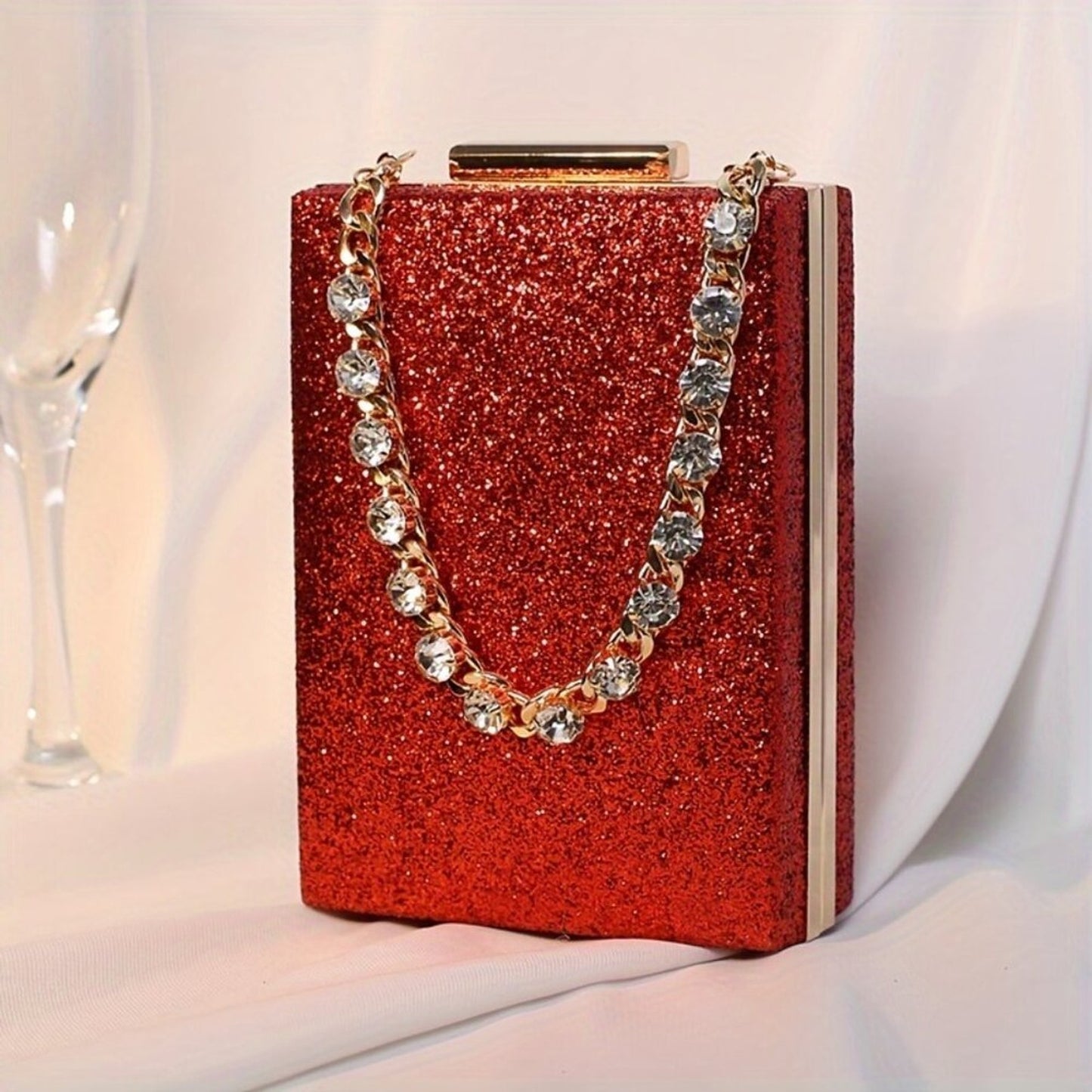 Red glittery handbag with a chain strap on a white background