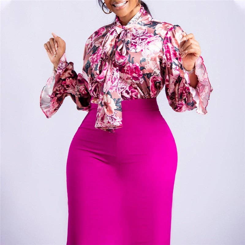 Woman wearing a floral blouse and pink skirt against a white background