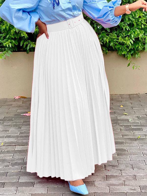 Person wearing a blue top and white pleated skirt on a paved surface with greenery in the background