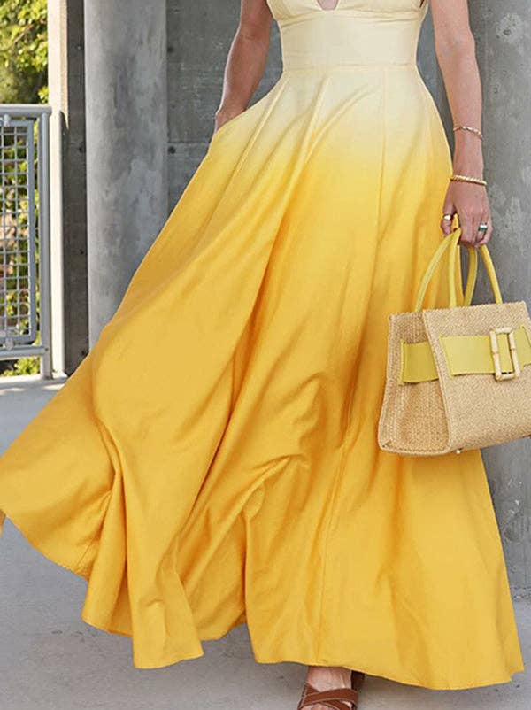 Person wearing a yellow dress holding a matching handbag against a concrete wall.