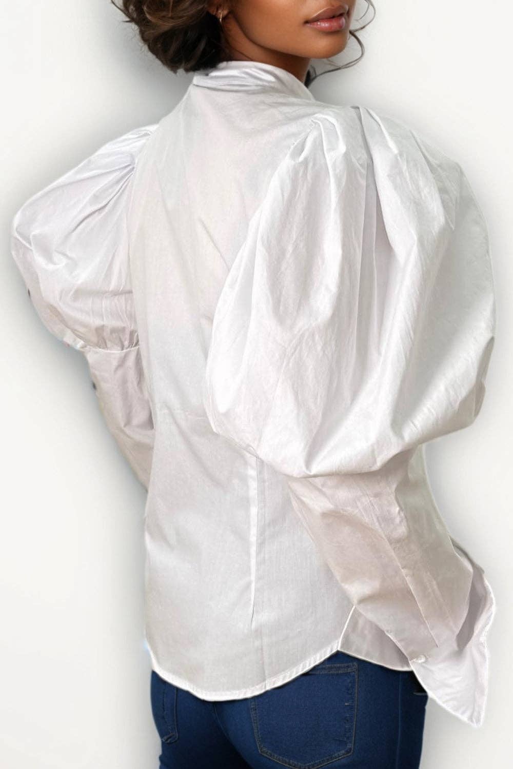 White blouse with puffed sleeves worn by a person on a white background