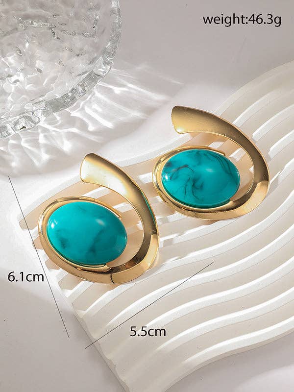 Gold earrings with turquoise stones on a textured white surface, showing measurements and weight.
