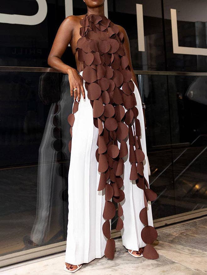 Woman wearing a unique dress with brown circular patterns in an indoor setting.