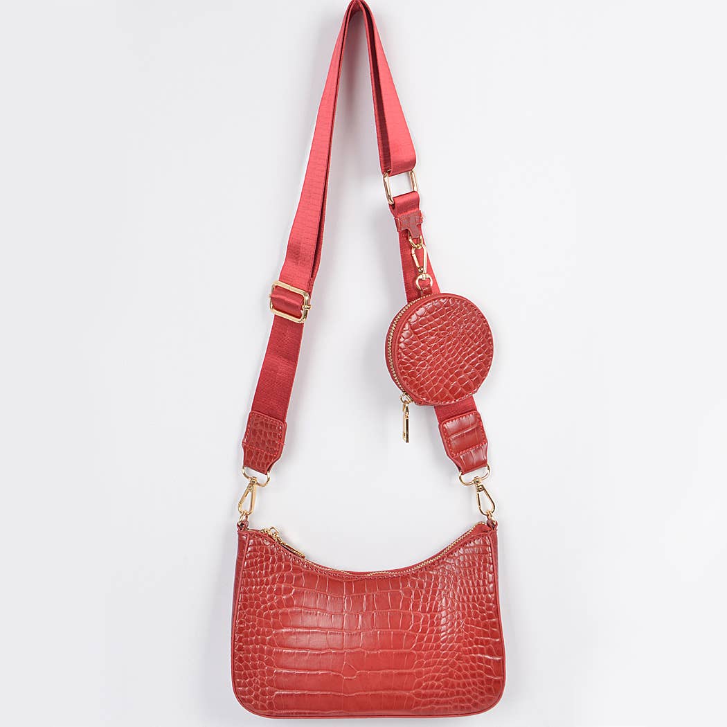 Red handbag with matching strap on a white background