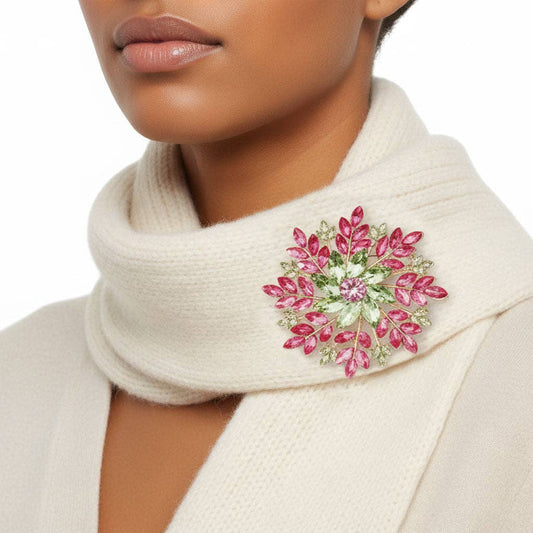 Close-up of a woman wearing a beige scarf with a pink floral brooch.