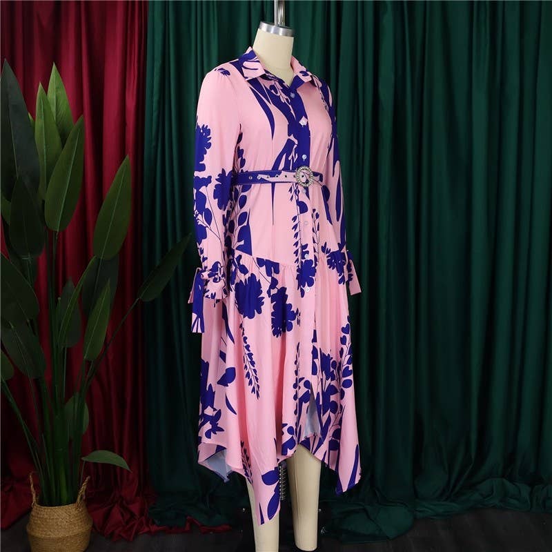 Mannequin wearing a pink dress with blue floral pattern against a green curtain background