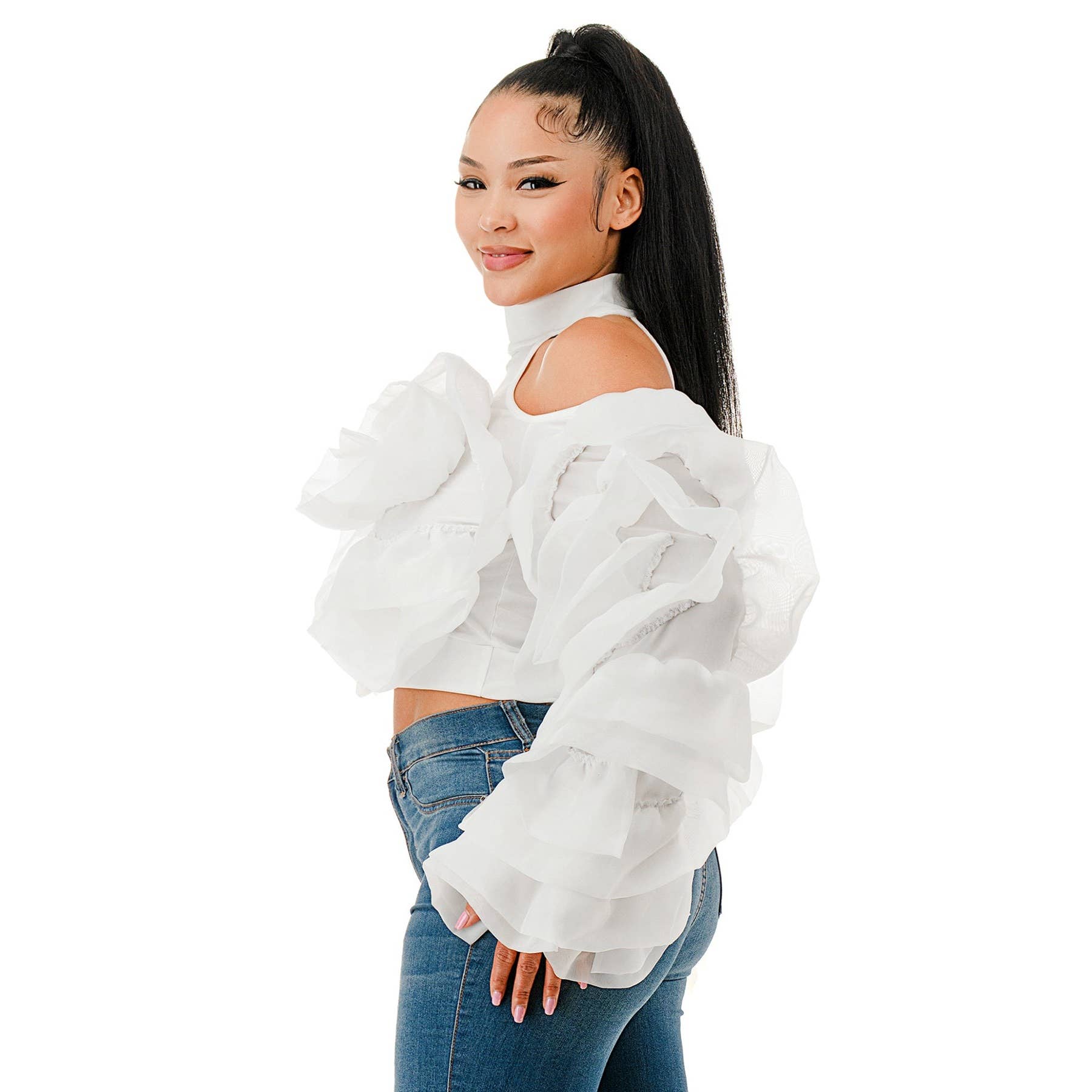 Woman wearing a white off-shoulder top and blue jeans on a white background