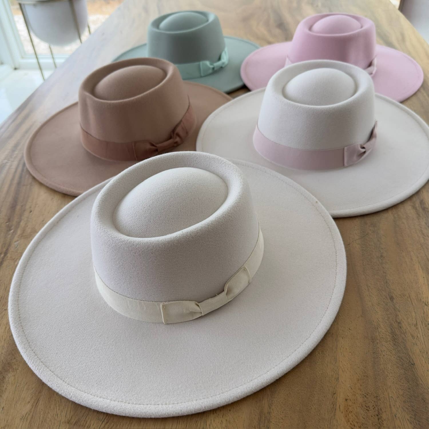 Set of four hats in different colors on a wooden surface
