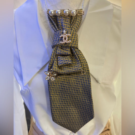 Patterned dress with decorative elements on a mannequin against a white background