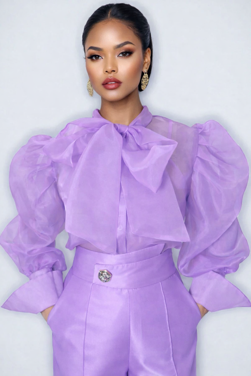 Woman wearing a lavender outfit with a large bow on a white background