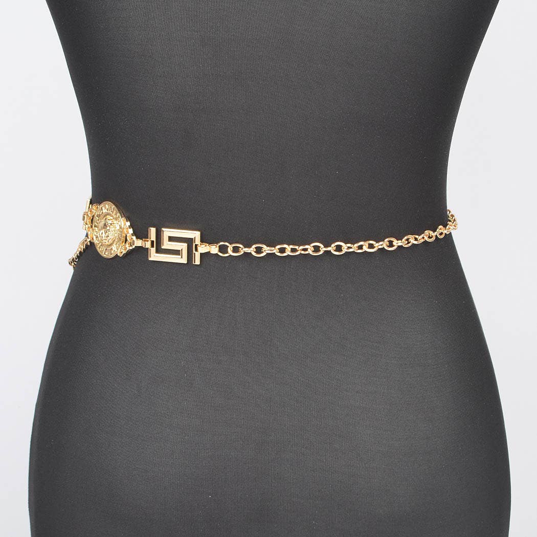 Gold chain belt with decorative clasp on a mannequin against a gray background