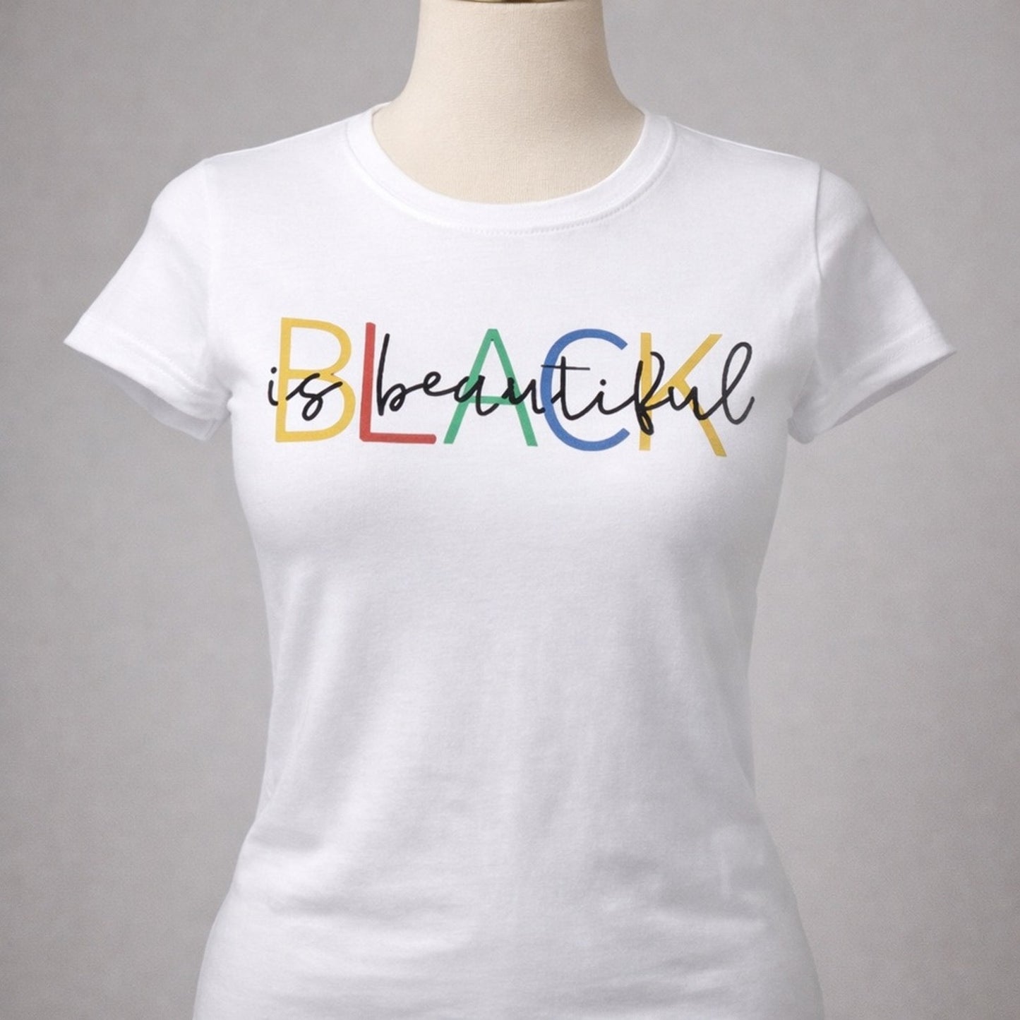 White t-shirt with 'is beautiful' text in colorful letters on a gray background