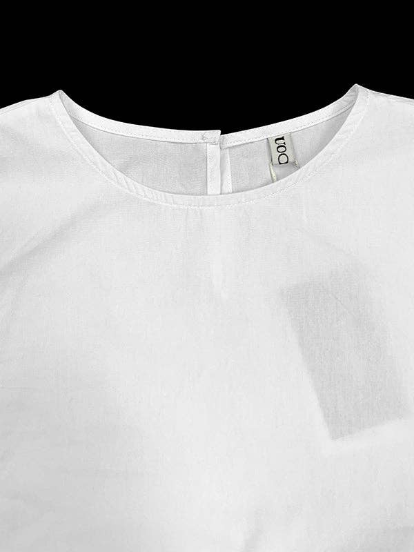 White blouse with a brand label on a black background