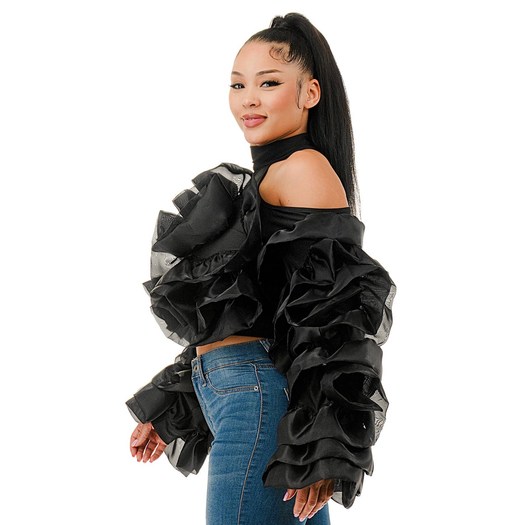 Woman wearing a black ruffled top and blue jeans on a white background