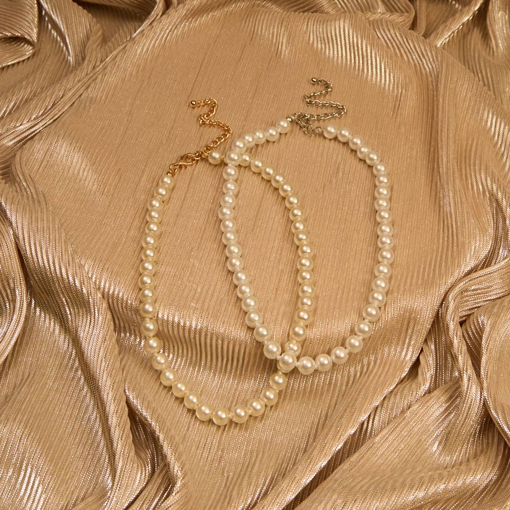 Pearl necklace on a textured beige fabric background