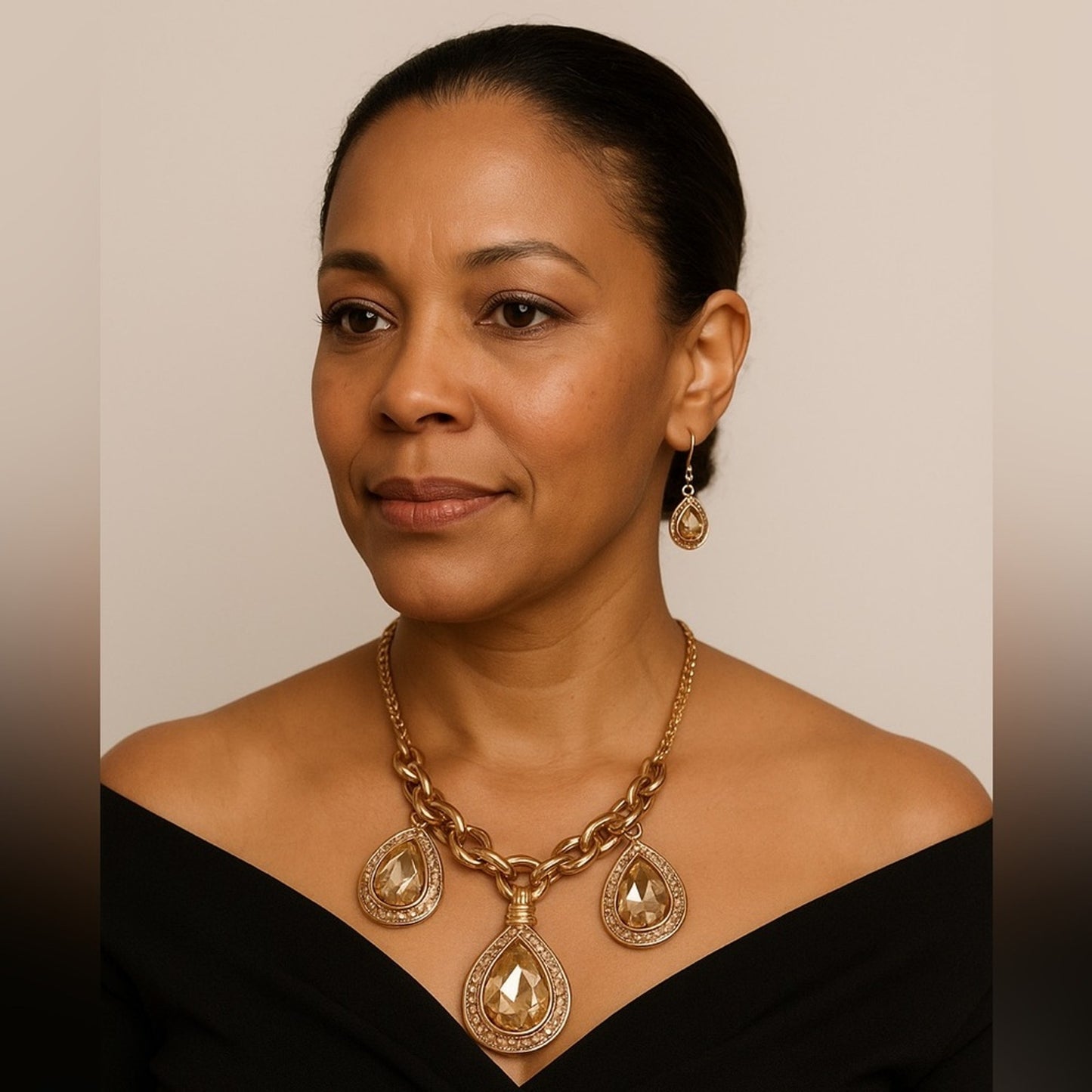 Woman wearing a gold necklace and earrings against a neutral background