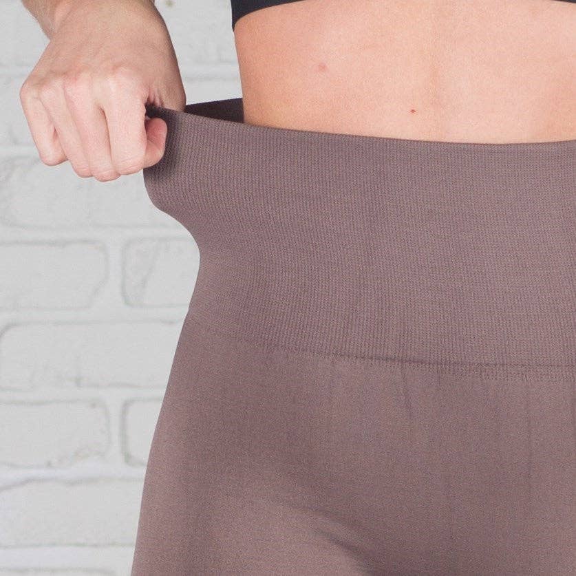 Person wearing a brown skirt with a neutral background