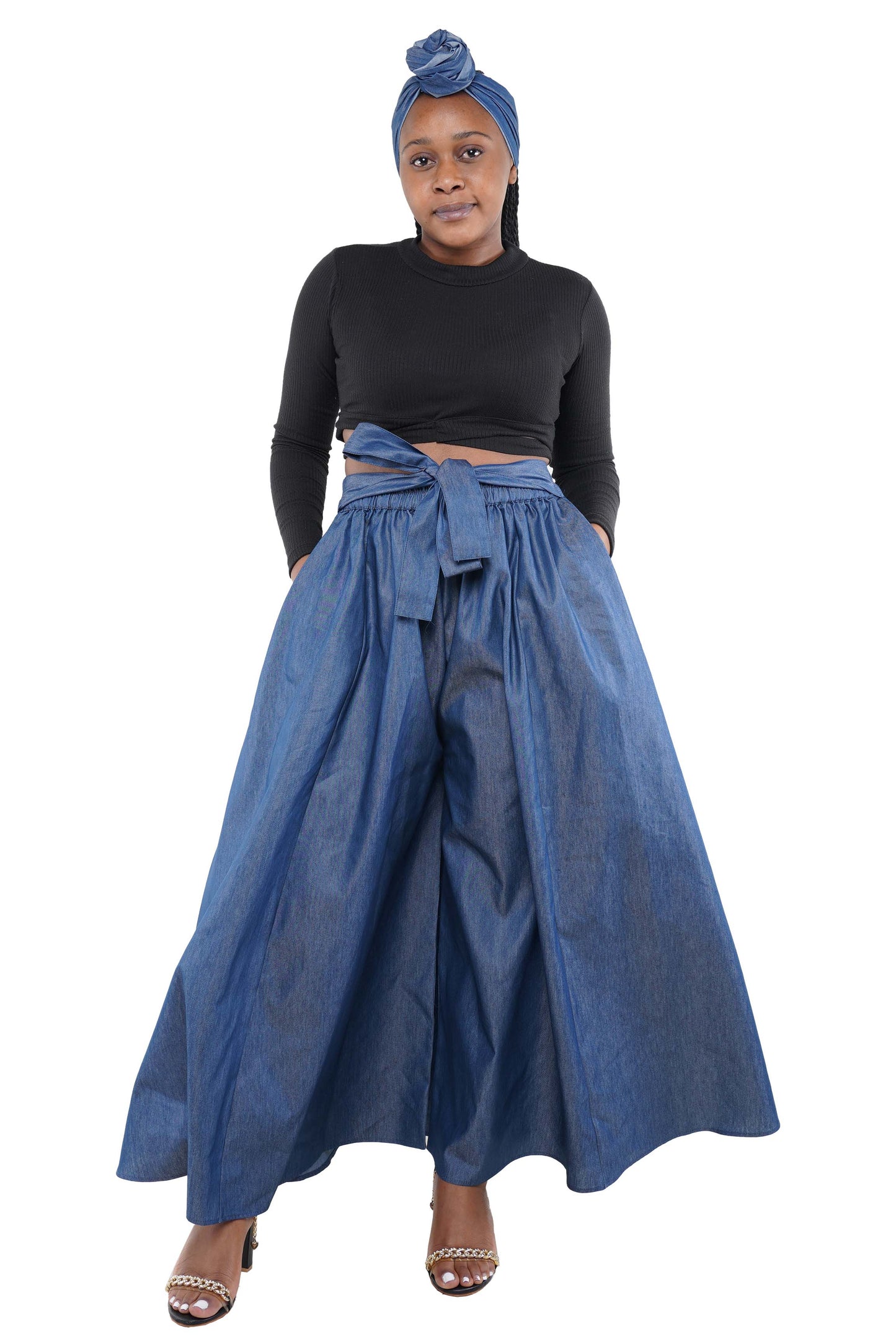 Woman wearing a black top and blue denim skirt with a headscarf on a white background