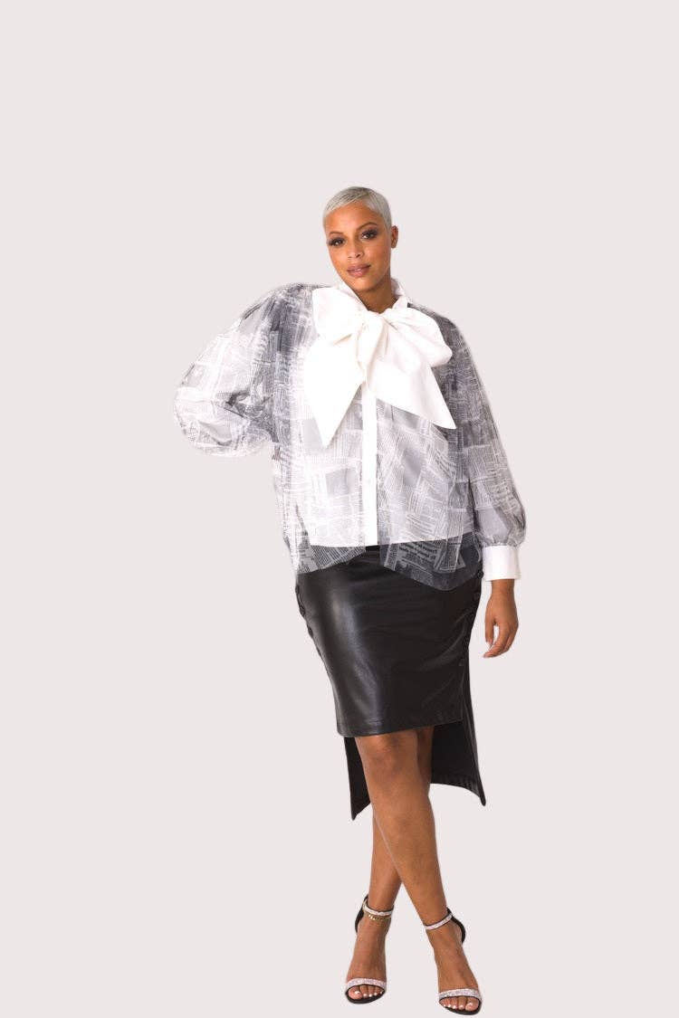 Woman wearing a checkered blouse with a large bow and a black leather skirt on a white background