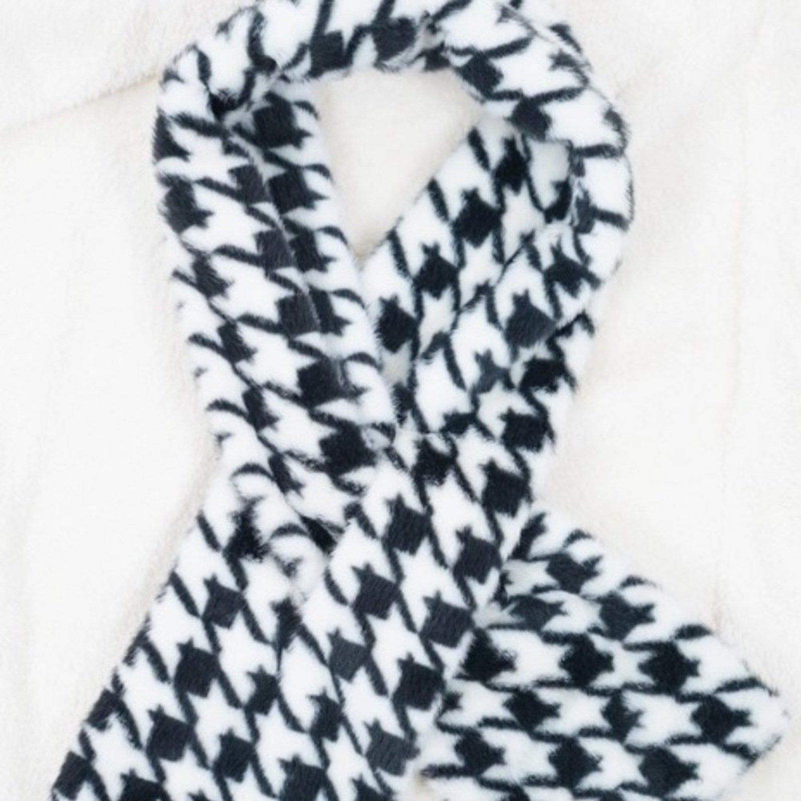Black and white houndstooth patterned scarf on a white background