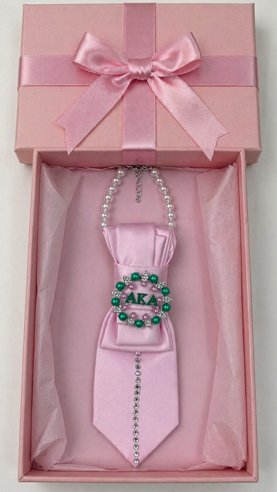 Pink tie with decorative elements in a gift box with a pink ribbon.