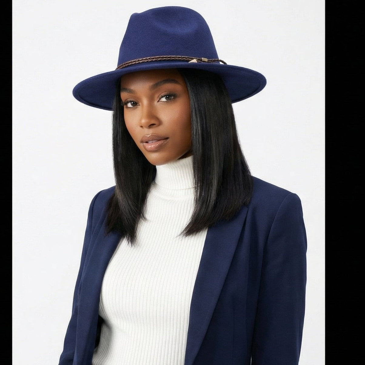 Woman wearing a navy blue suit and hat on a white background