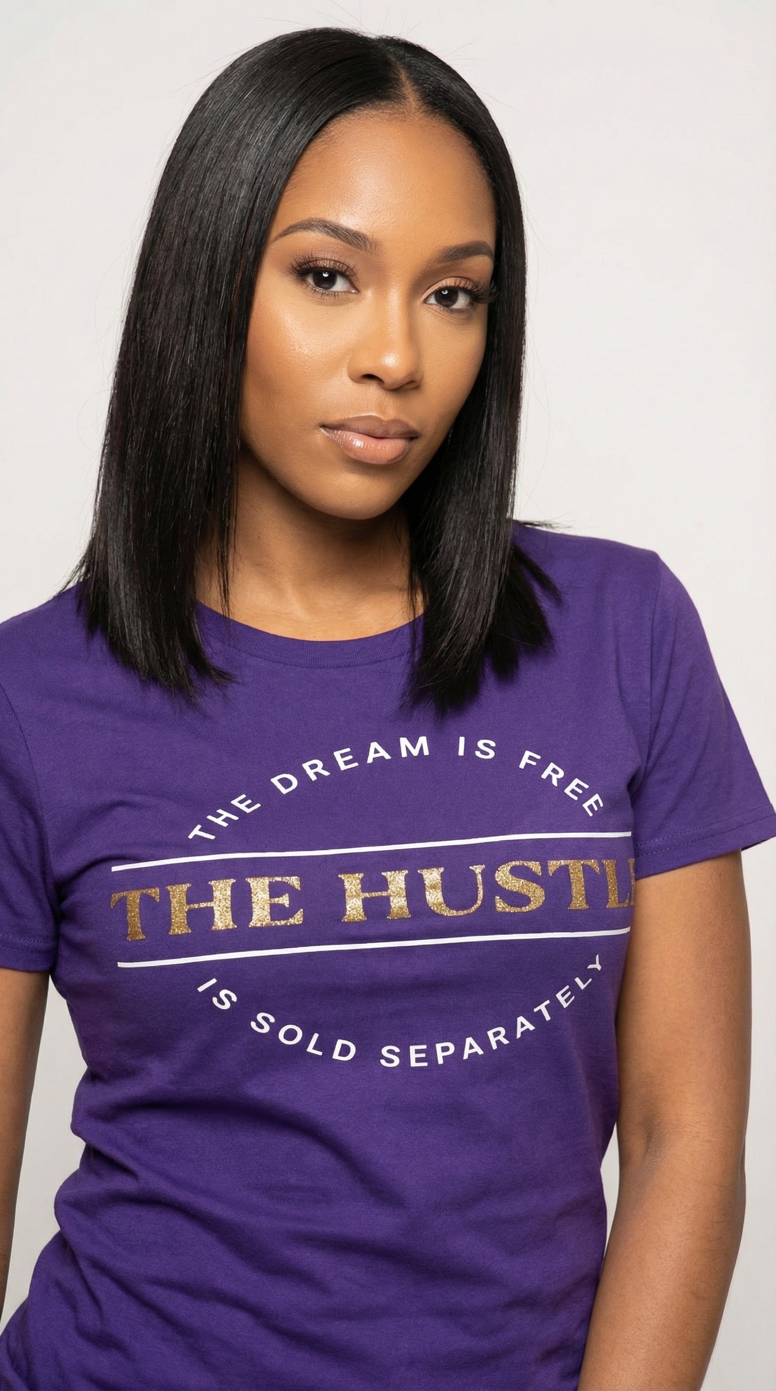 Woman wearing a purple t-shirt with text design on a plain background