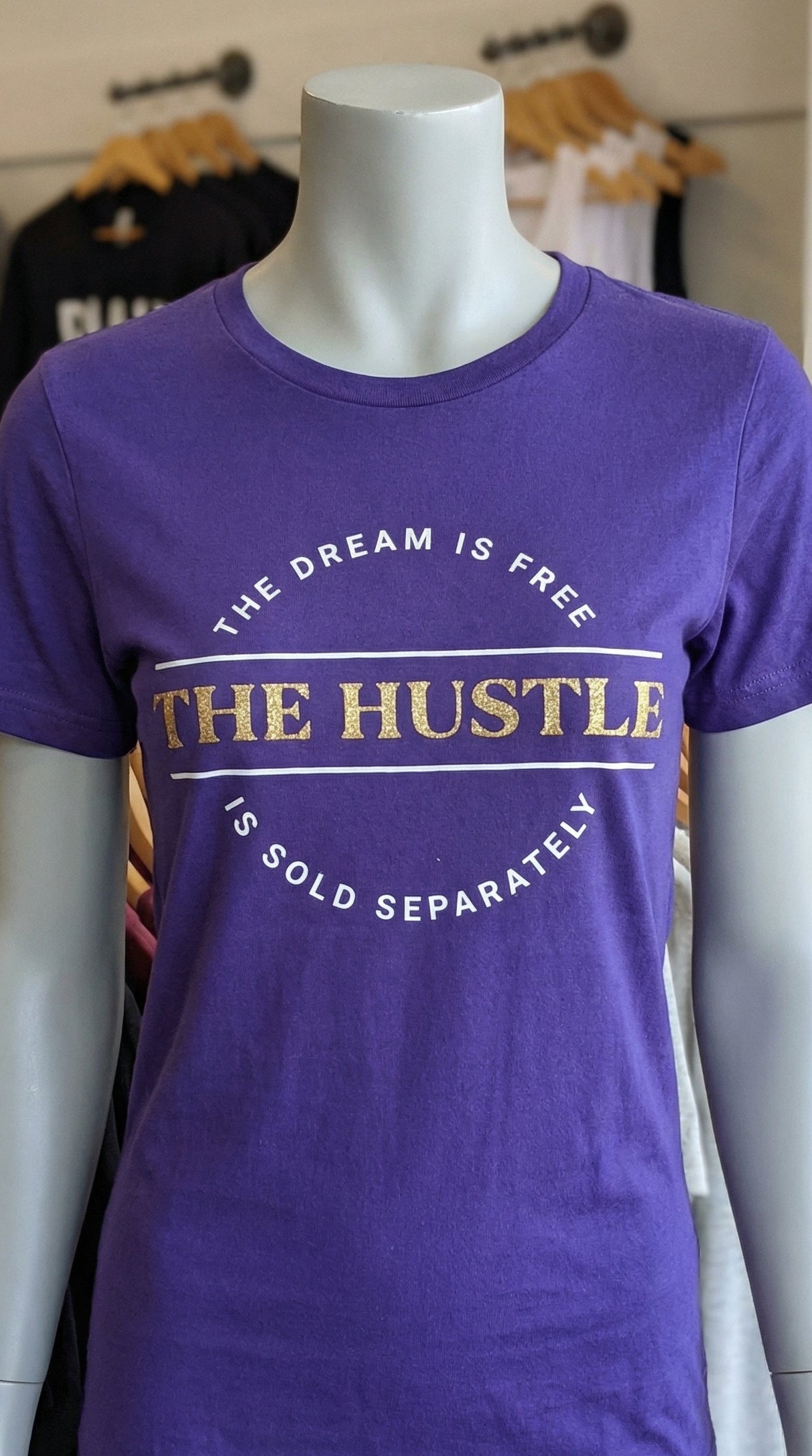 Purple t-shirt with text on a mannequin in a store setting