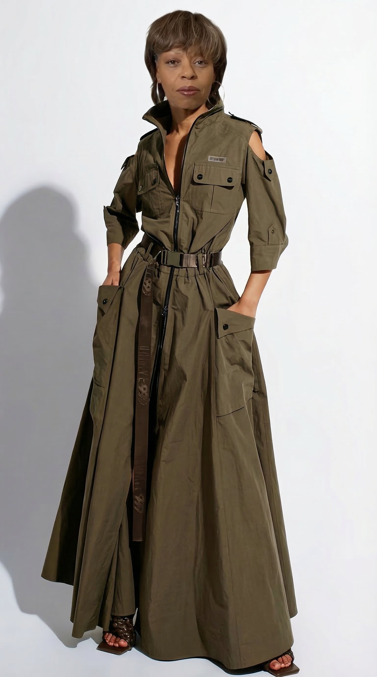 Woman wearing a long olive green trench coat on a white background