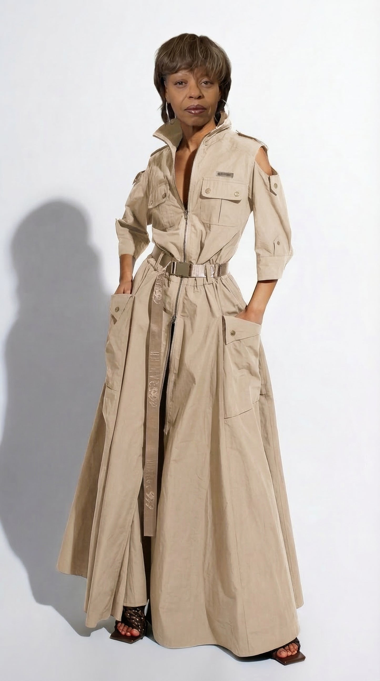 Woman wearing a long beige trench coat on a white background