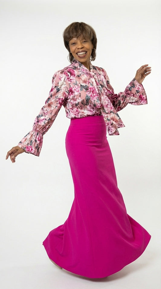 Woman wearing a floral blouse and pink skirt on a white background