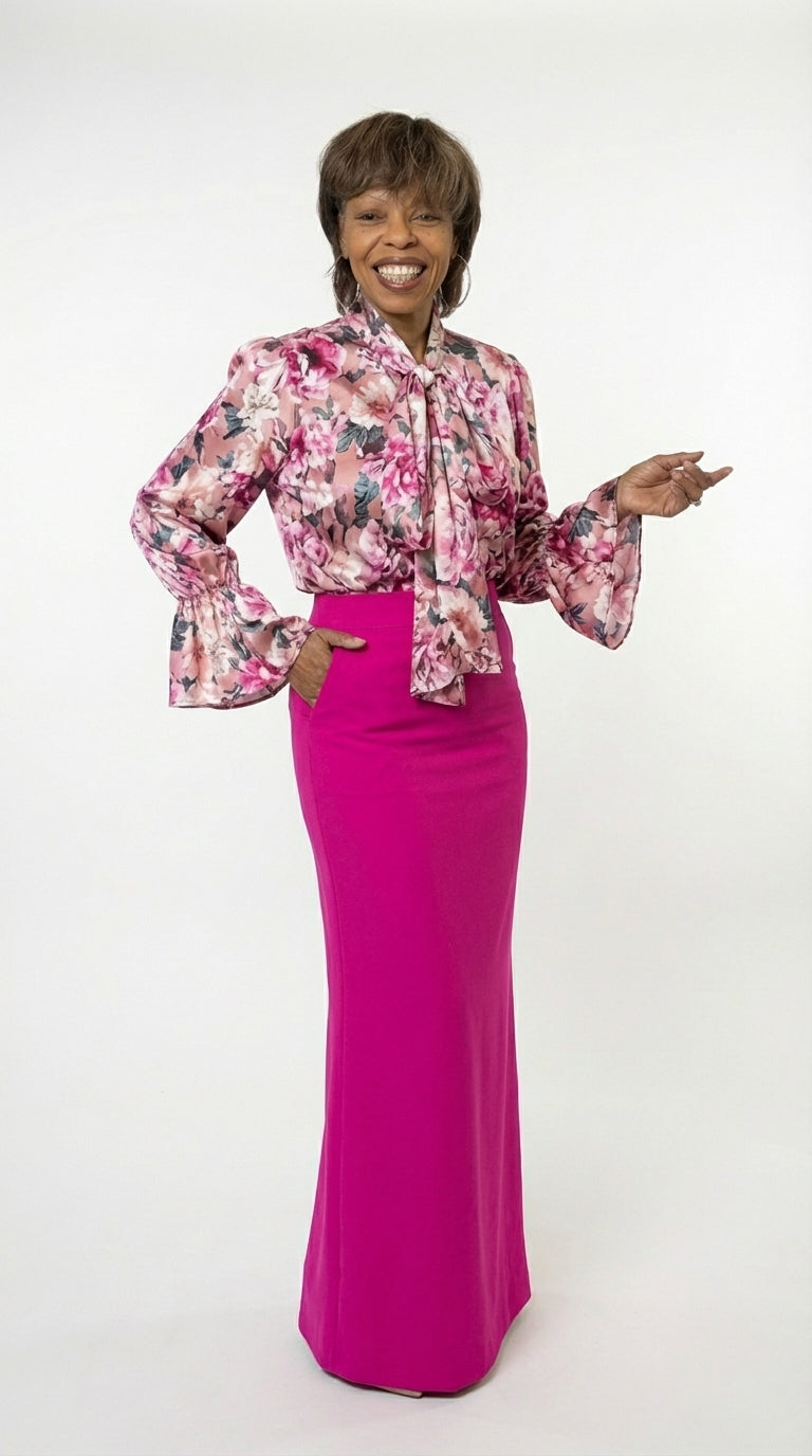 Woman wearing a floral blouse and pink skirt on a white background