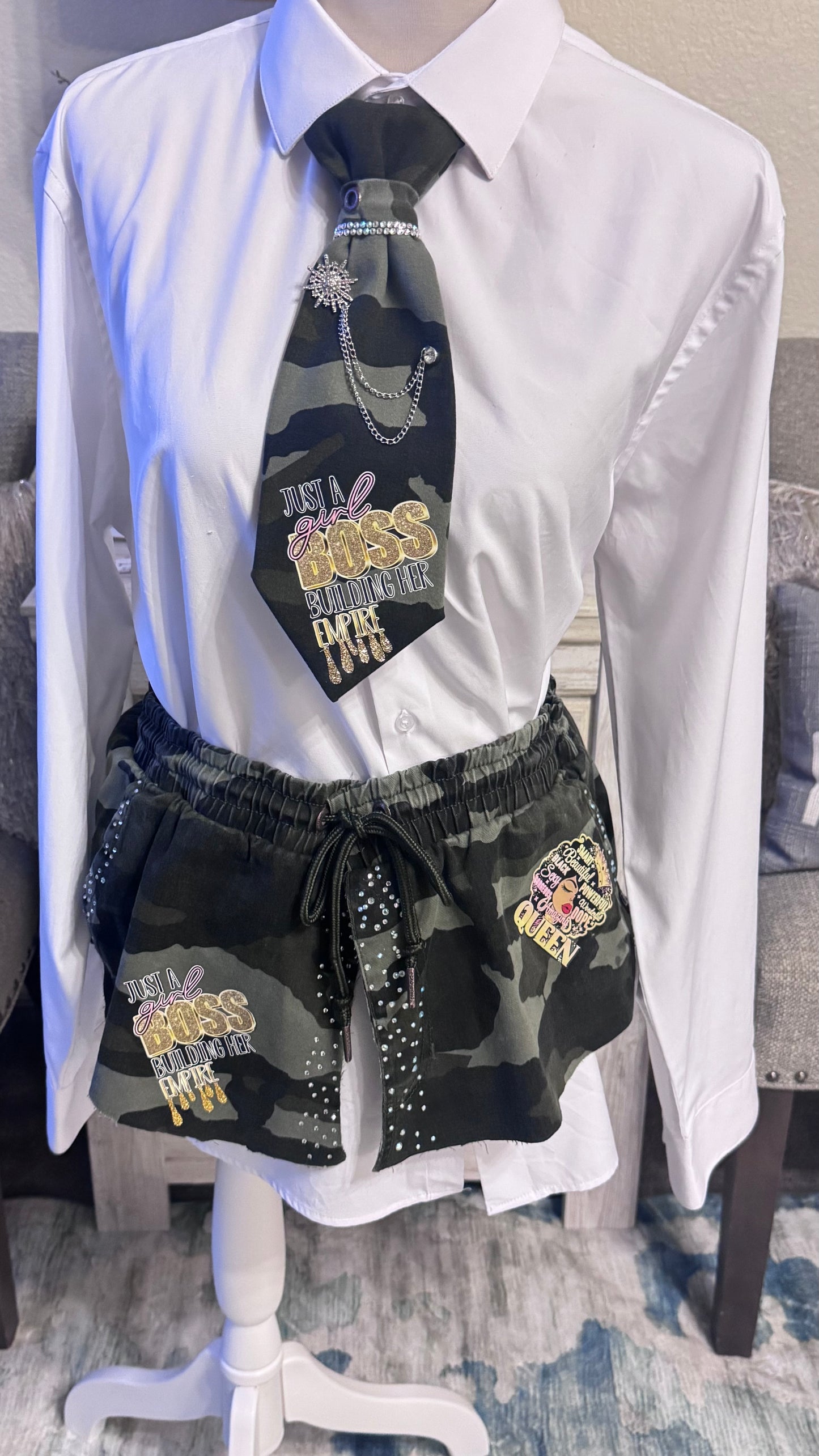 White shirt with a black tie and camouflage shorts on a mannequin.