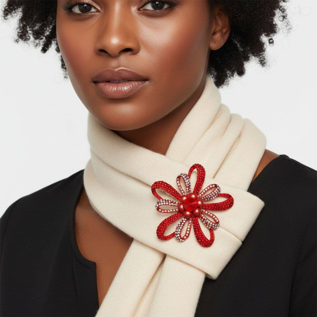 Woman wearing a white scarf with a red floral brooch against a light background