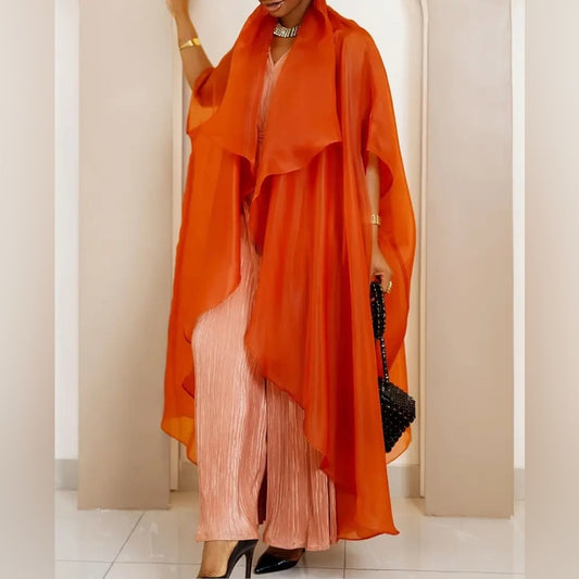 Person wearing an orange duster over a pink dress with a black clutch.