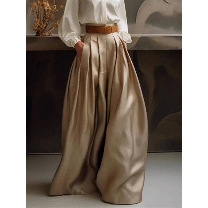 Person wearing a white shirt and beige wide-leg pants with a brown belt.
