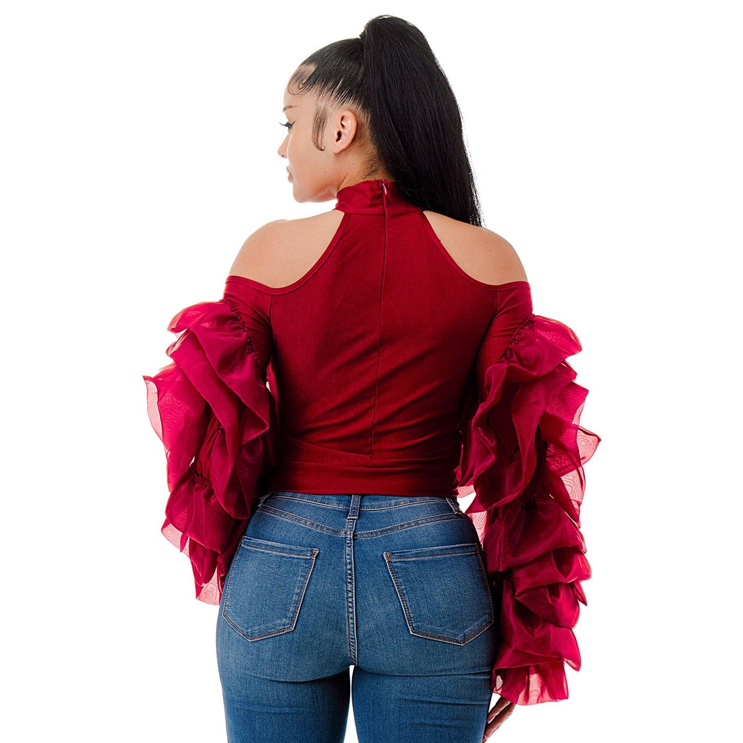 Person wearing a red off-shoulder top with ruffled sleeves and blue jeans on a white background