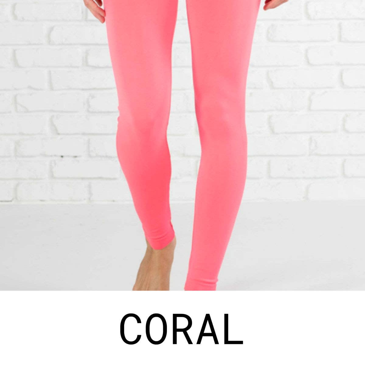 Coral leggings worn by a person against a white brick wall.