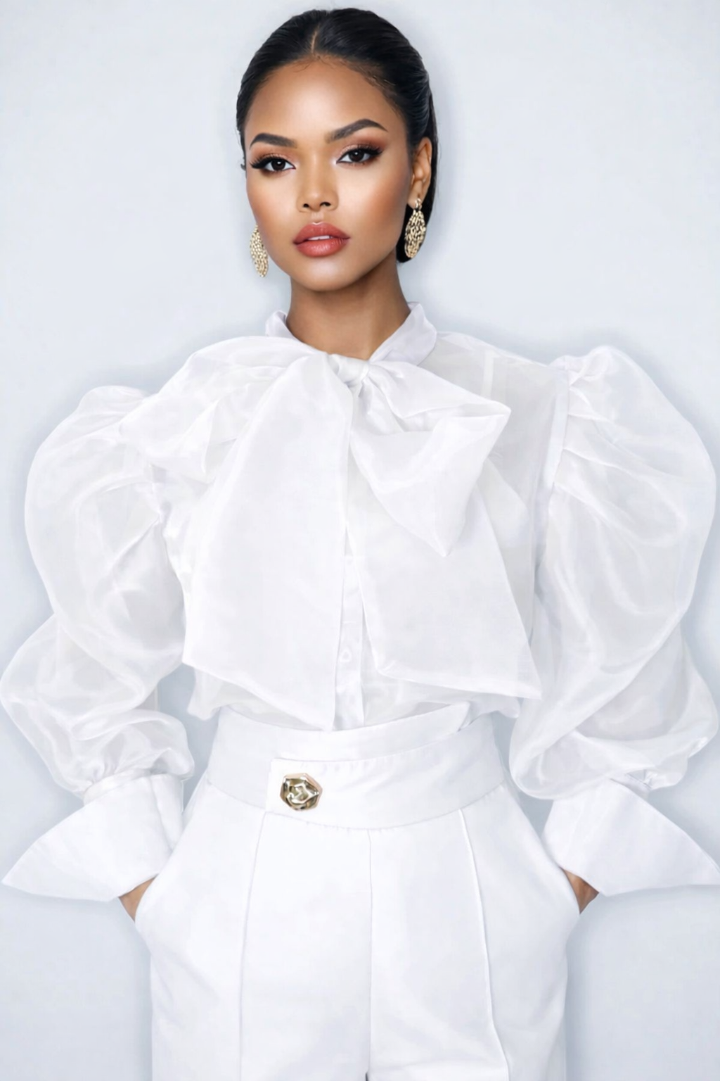 Woman wearing a white outfit with puffed sleeves against a light gray background