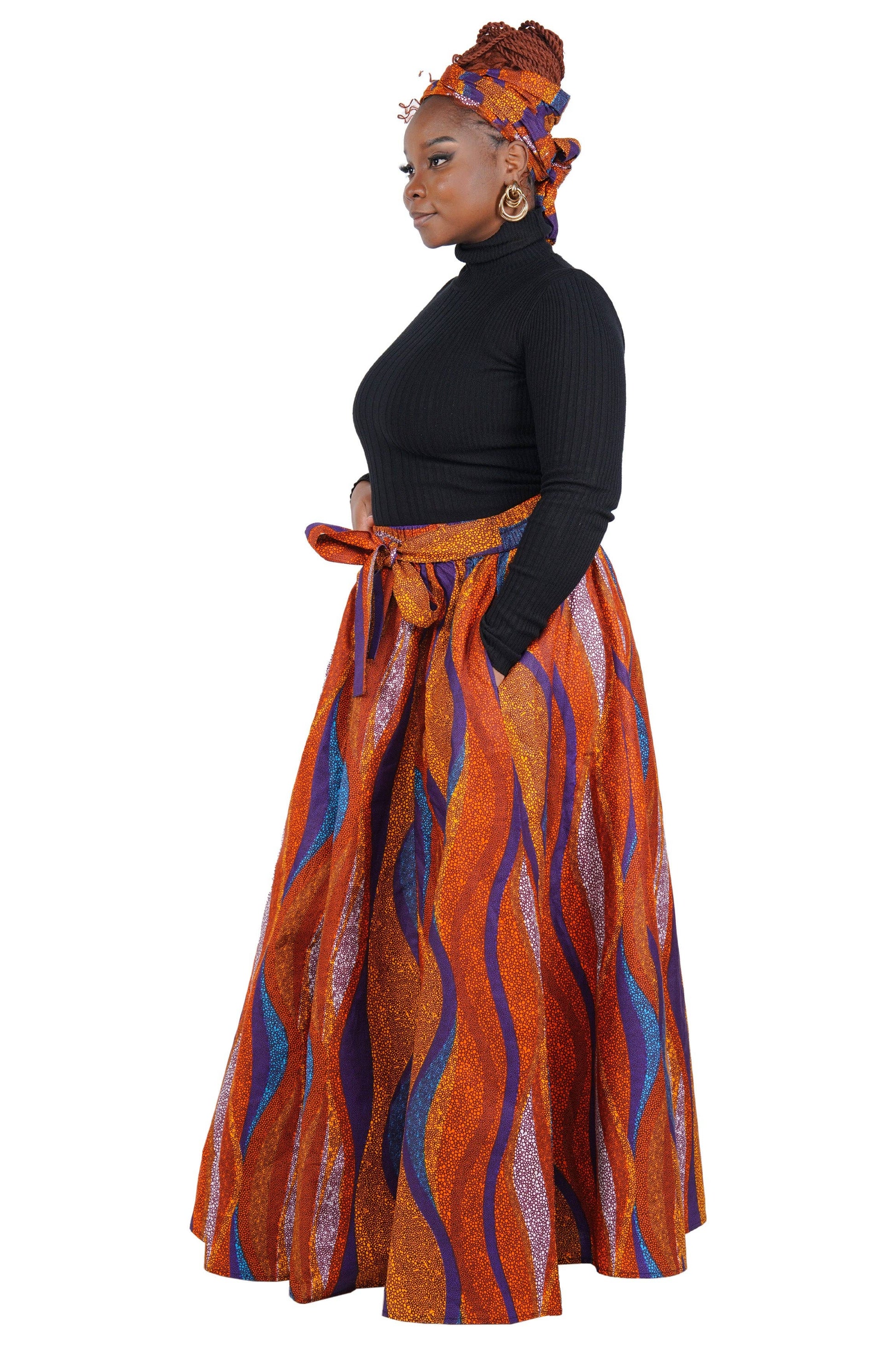 Woman wearing a traditional outfit with an orange and blue patterned skirt on a white background