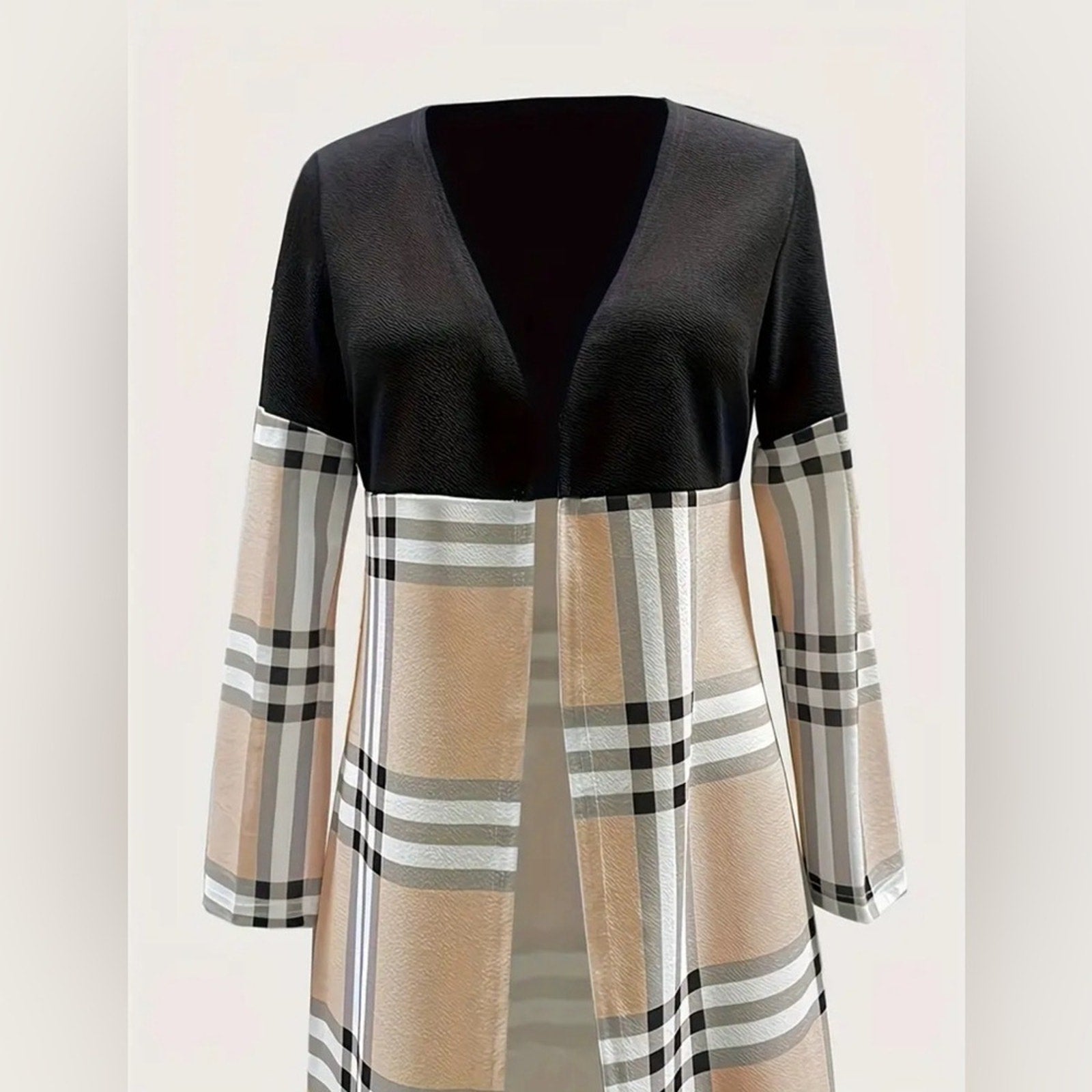 Black top with plaid sleeves and skirt on a light pink background