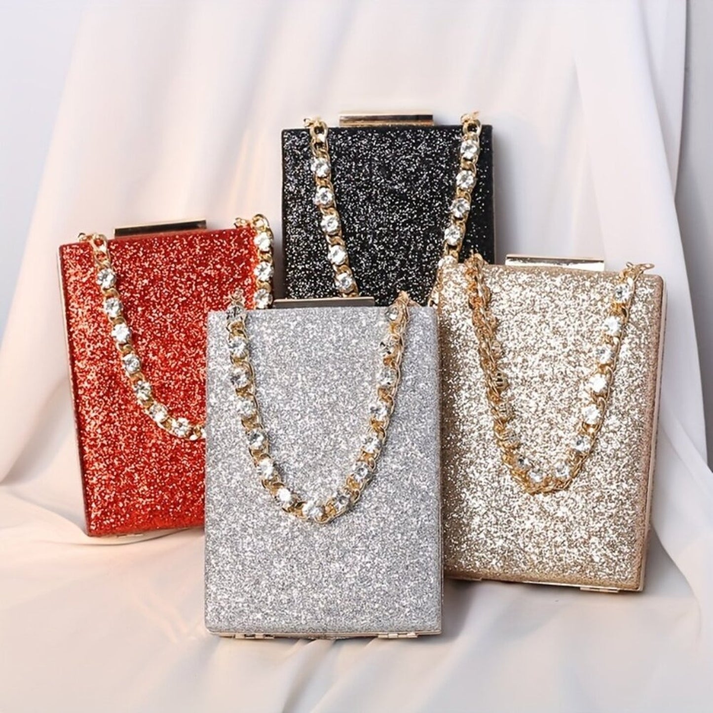 Four glittery handbags in red, black, silver, and gold on a light background