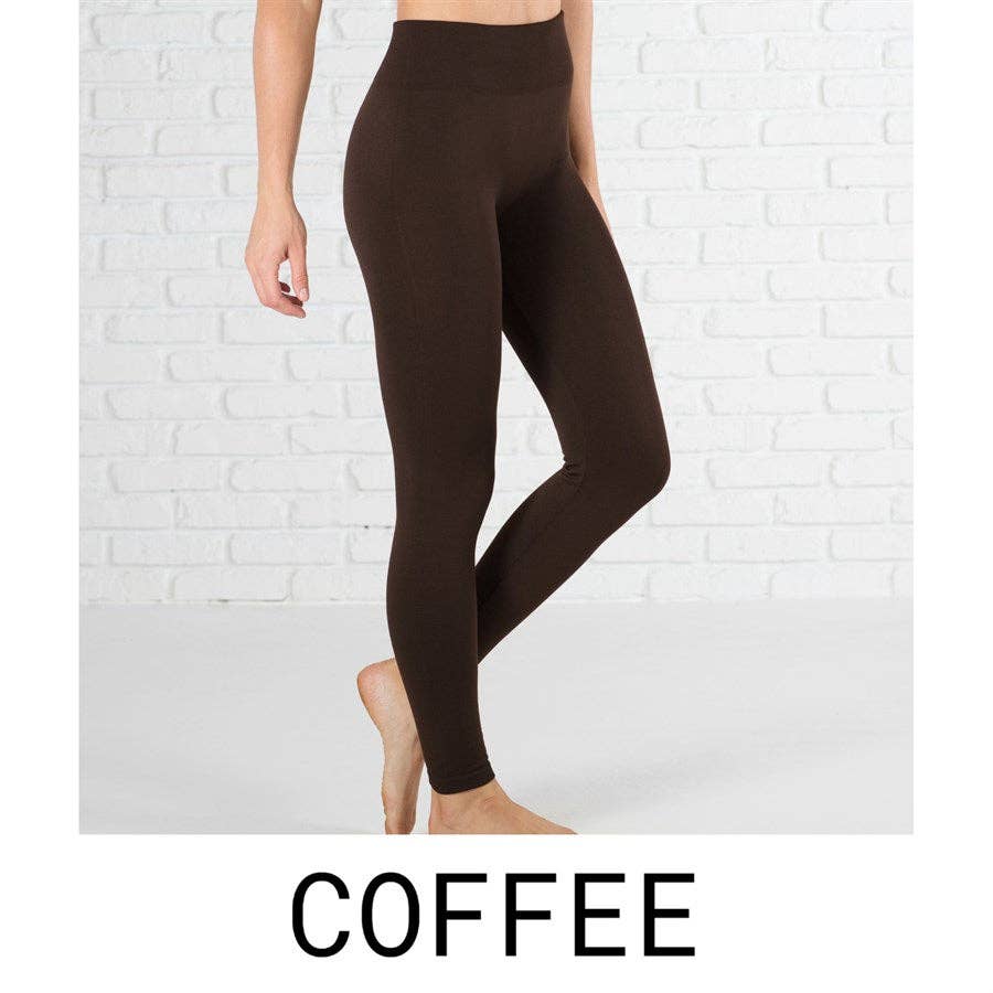 Brown leggings worn by a person on a white brick wall background with 'COFFEE' text at the bottom.