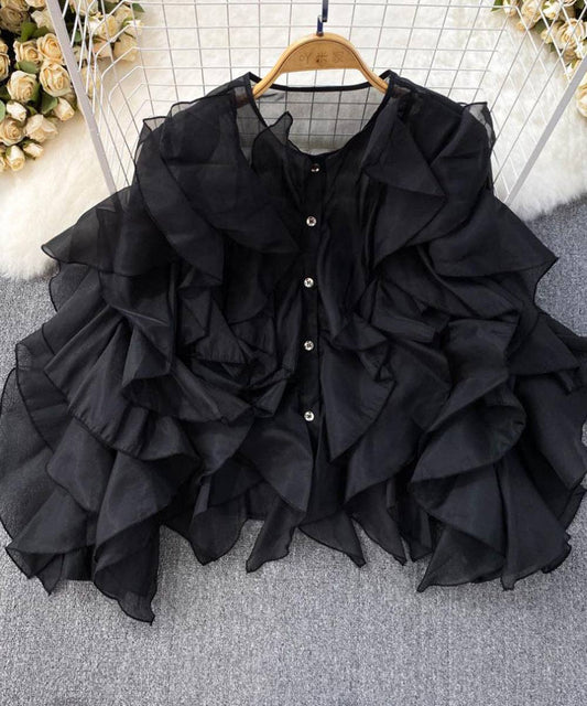 Black ruffled blouse on a hanger with a neutral background