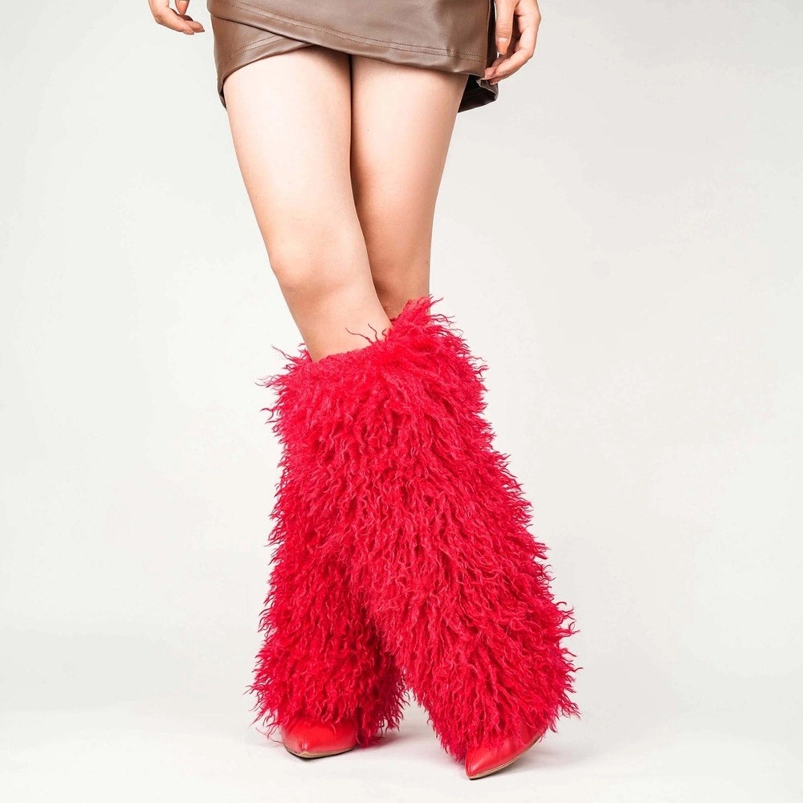 Red furry boots worn with a plain background