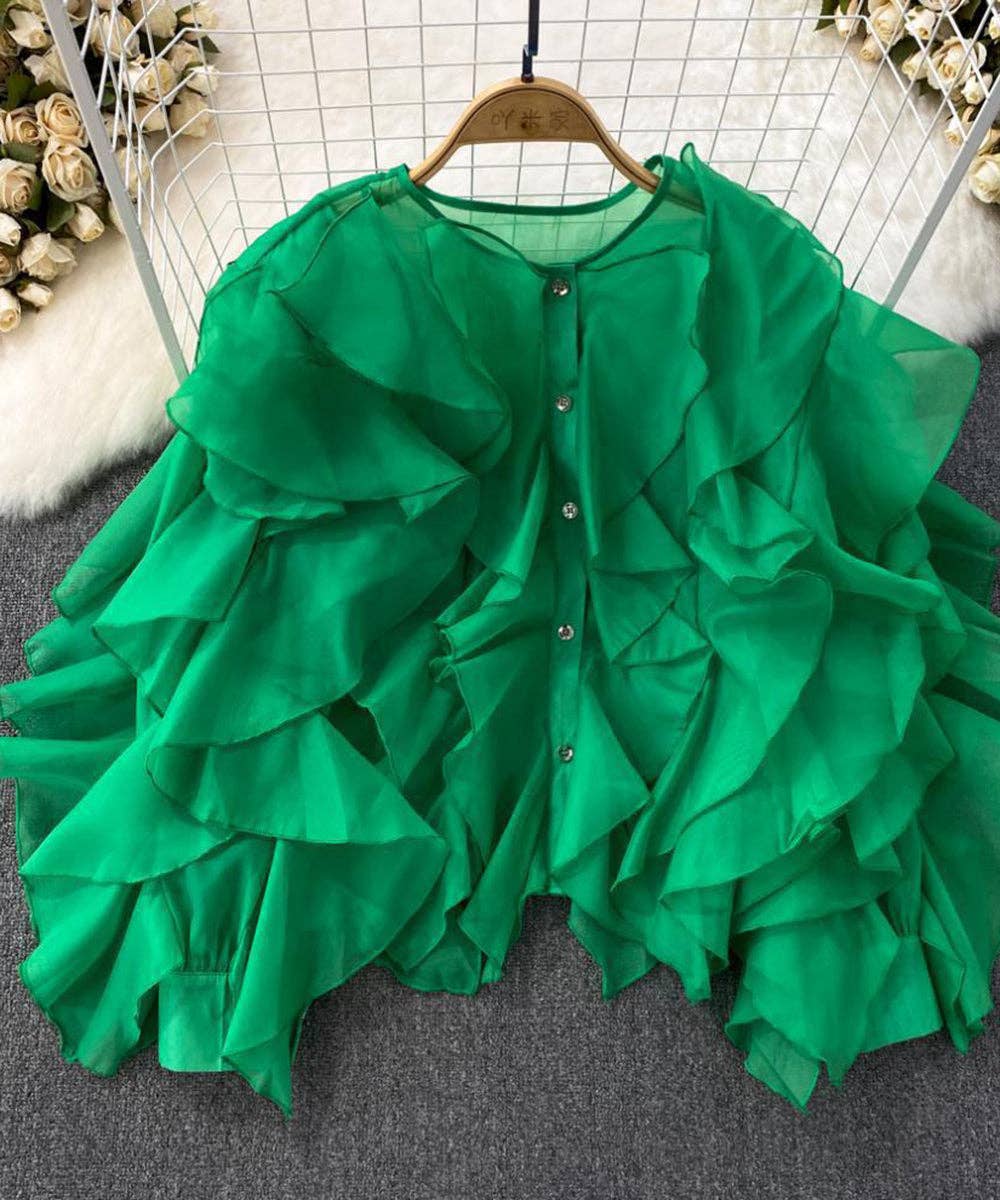 Green ruffled blouse on a hanger with a neutral background
