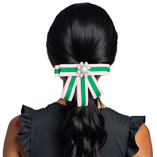 Green and pink hair clip with decorative element on a white background