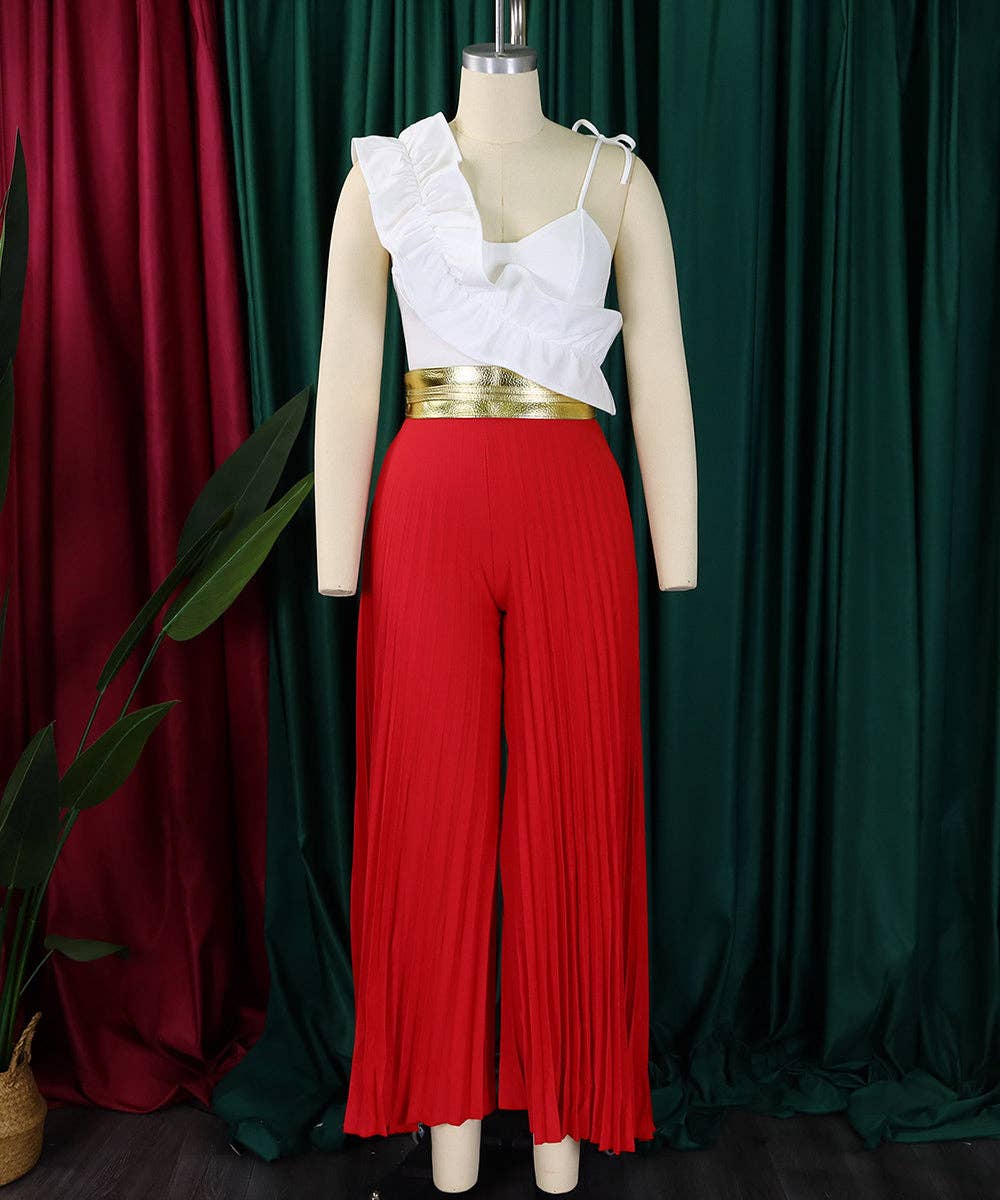 Mannequin wearing a white top with ruffled details and red pleated pants against a green curtain background.